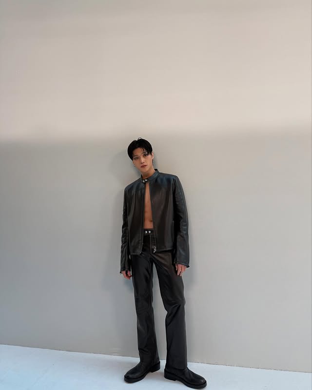 Asian male model in black leather outfit against minimalist gray background