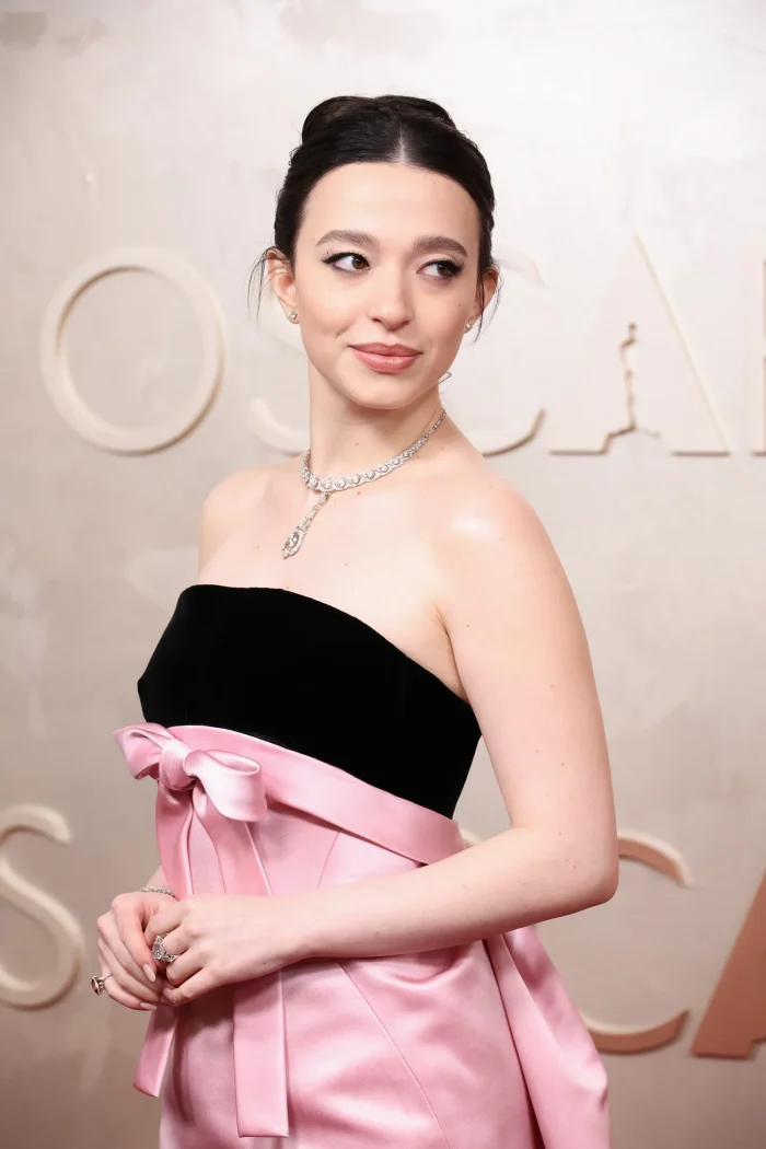Elegant figure in black and pink strapless gown with diamond necklace at formal event