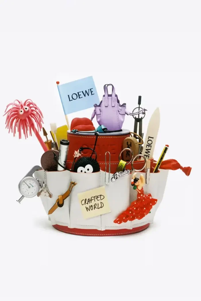 Loewe Crafted World collection featuring playful accessories and miniature items in a decorative container