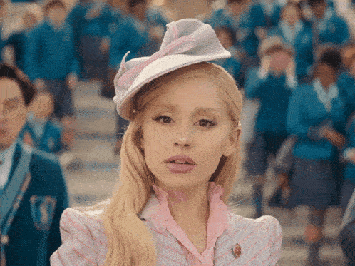 Vintage-style portrait of person in pink outfit and matching hat with crowd background