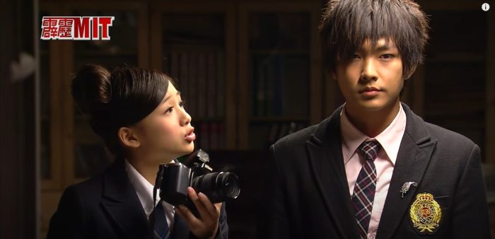 Girl holding a camera and looking at a boy