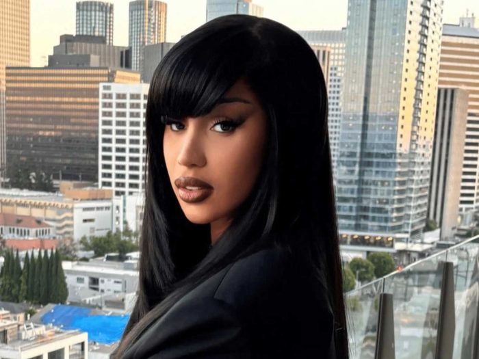 A photo of a woman wearing black outfit with buildings in the background