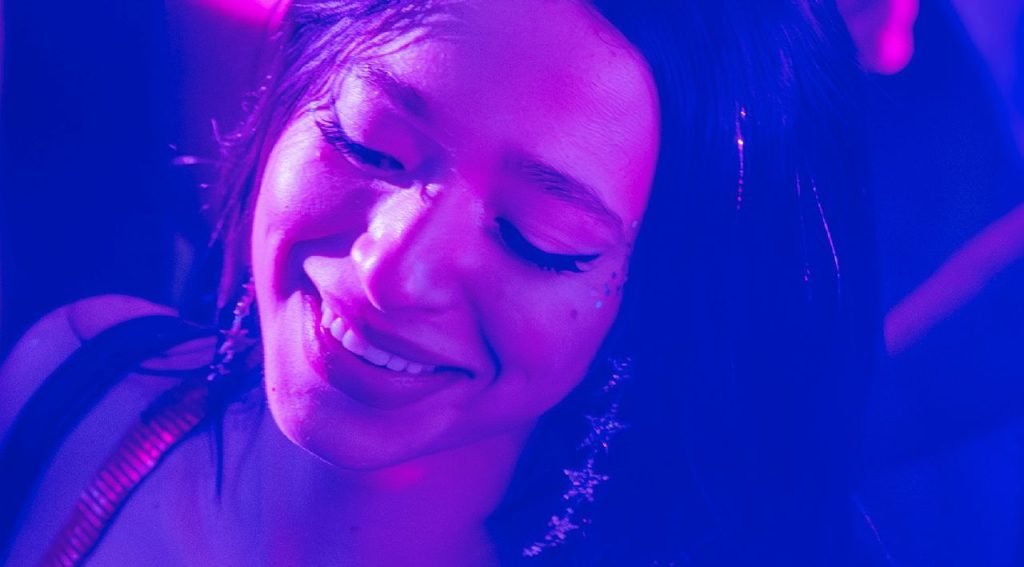 Joyful-expression-of-a-woman-captured-in-vibrant-neon-purple-and-blue-lighting