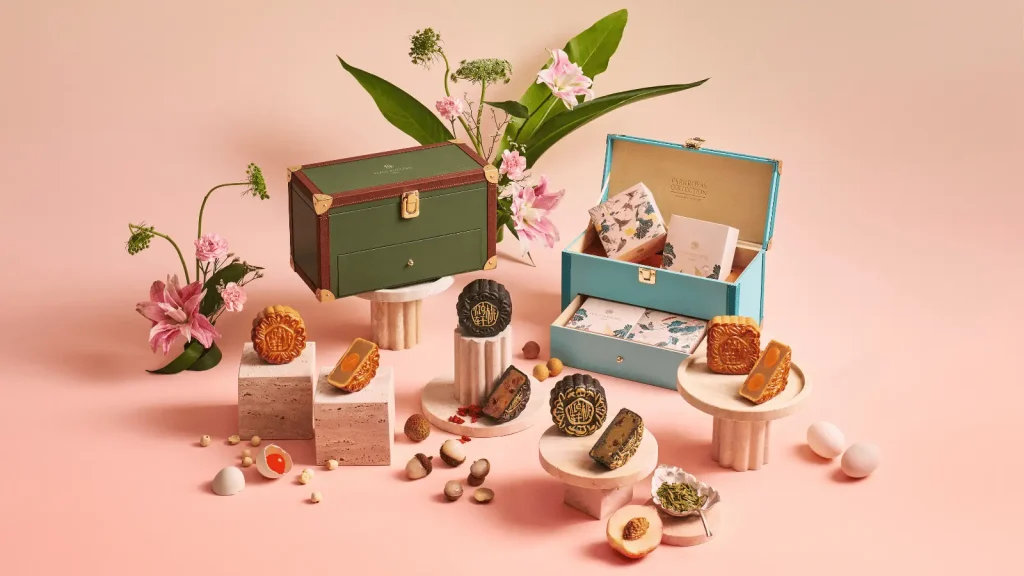Mooncake gift set with floral packaging and assorted mooncakes on pink background