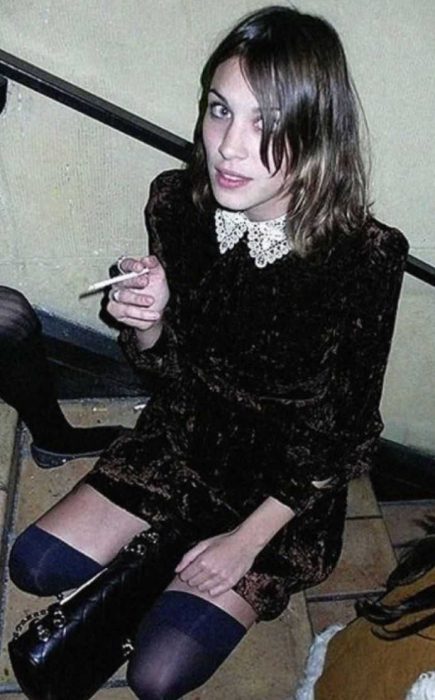 A woman wearing a black dress and a black high socks